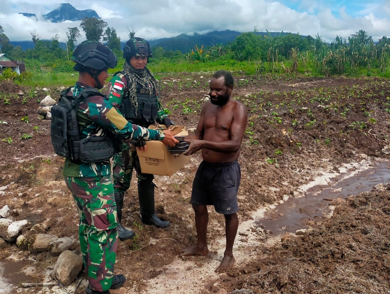 Bantu olah lahan, Satgas Pamtas RI-PNG Yonif Raider 142/KJ bagikan susu dan roti