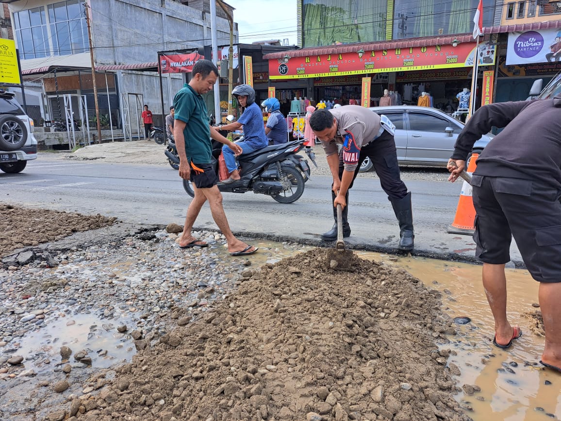 Polisi tambal bahu jalan yang rusak akibat banjir Aceh Utara Polisi tambal bahu jalan yang rusak akibat banjir Aceh Utara