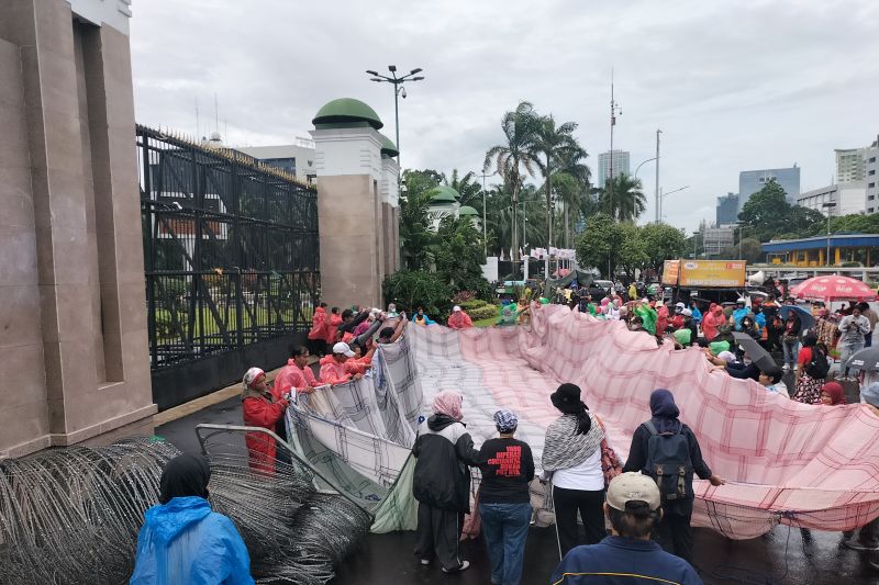 Serbet raksasa dibentangkan saat ratusan PRT demonstrasi di gedung DPR Serbet raksasa dibentangkan saat ratusan PRT demonstrasi di gedung DPR