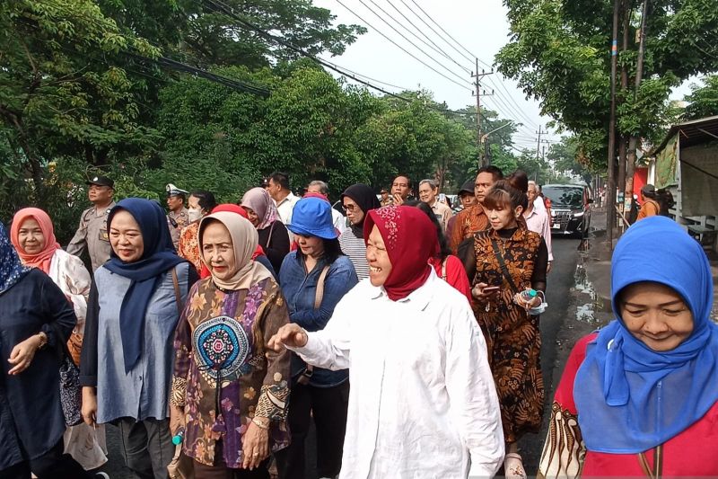 Risma jalan kaki ke TPS dikawal emak-emak Risma jalan kaki ke TPS dikawal emak-emak