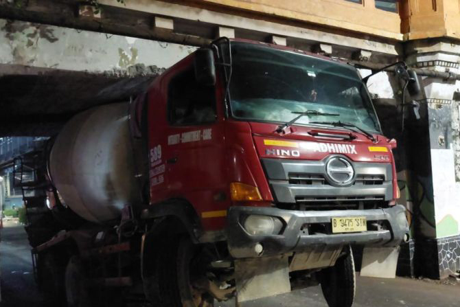 Truk molen tersangkut di kolong jembatan kereta di Matraman