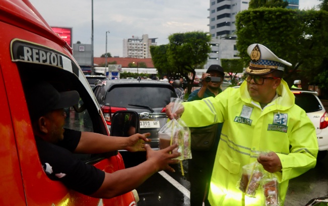 Puluhan polisi basah kuyup di tengah hujan bagikan takjil untuk warga Puluhan polisi basah kuyup di tengah hujan bagikan takjil untuk warga